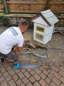 A man building a little free library